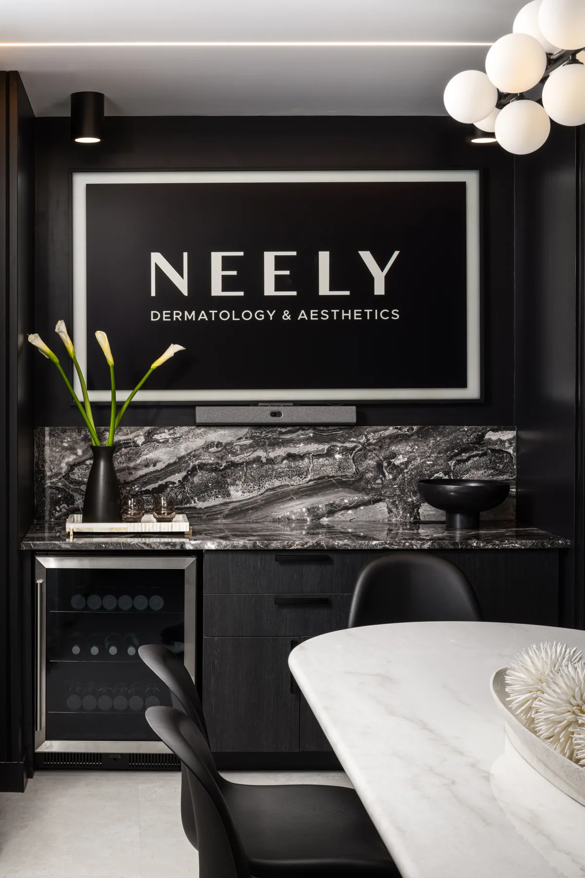 Neely sign above strongly patterned stone backsplash and black cabinetry.
